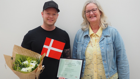 FOA Odenses formand Nina Skov-Lauridsen lykønsker velfærdstalent Tommy Andersen med flag og buket